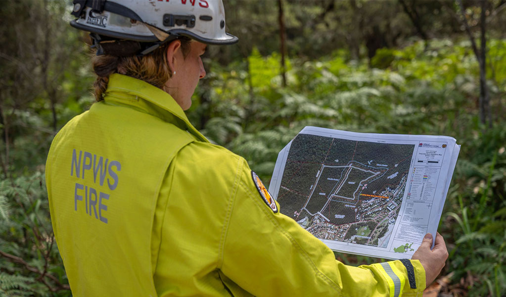 NPWS Fire Crew Member looking at a map while on site. Credit: John Spencer &copy; DCCEEW