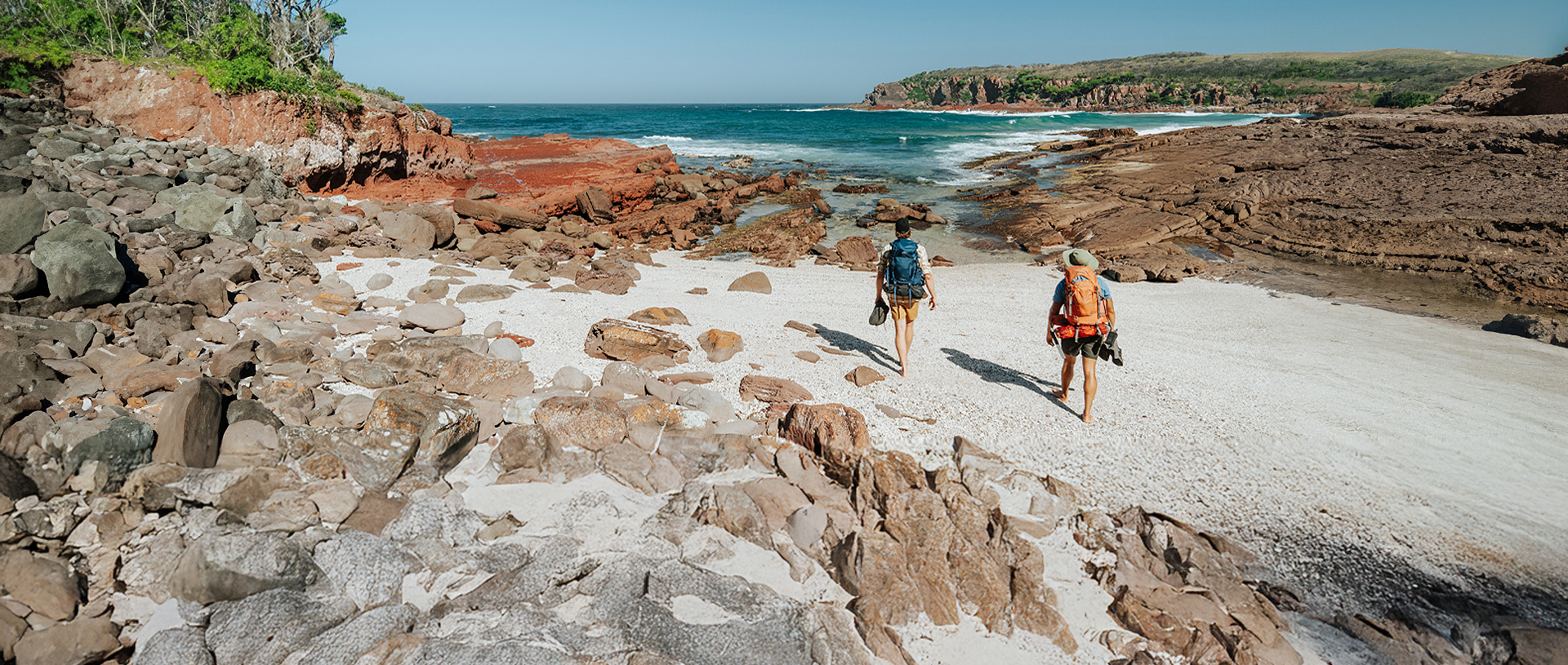 Hikers arriving at Hegartys Bay, a small rocky beach. Credit: Remy Brand/DCCEEW © Remy Brand