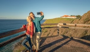 A couple taking a selfie near the Assistant Lighthouse Keepers Cottages in Walgun Cape Byron State Conservation Area. Photo: John Spencer &copy; DCCEEW