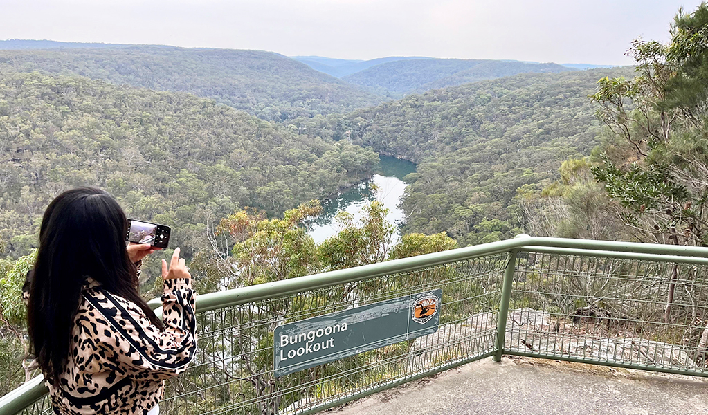 Woman takes photo of views from Bungoona lookout. Credit: Natasha Webb &copy; DCCEEW